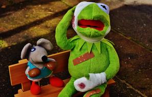 Kermit frog and colorful Mouse toy on the bench