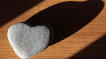 A heart of stone on the sand in the shade