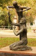 metal sculpture of two people in the park in autumn