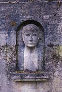 stone bust of a man in a cemetery