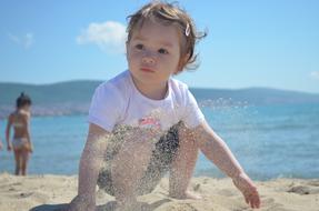 A small child is playing on the beach