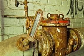 Close-up of the old, rusty machine, near the wall, in the factory