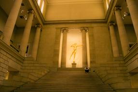 young man sits on staircase in historical building