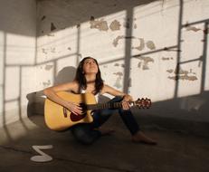 musician with a guitar in an empty room