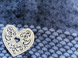 a silver heart on a blue sweater