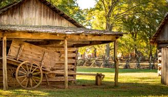 Beautiful landscape with the log building on the green meadow, among the colorful trees in America