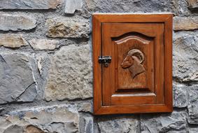 Brown, wooden locker with the goat pattern in the colorful stone house