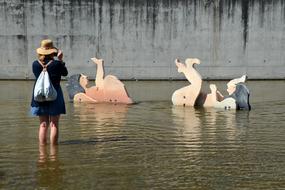 a girl near a sculpture in the water in lisbon