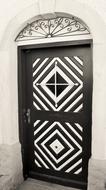 black wooden door with white patterns