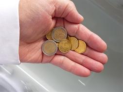 Close-up of the shiny metal Euro coins in the person's hand