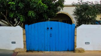 Blue Gate in white stone wall in front of house, cyprus, dherynia