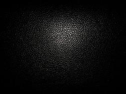 black leather background illuminated by light