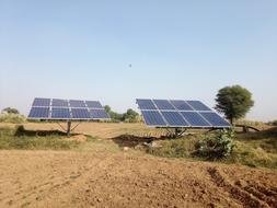 Shiny panels, on the colorful and beautiful fields with the plants, at blue, gradient sky