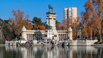 Beautiful landscape of the colorful park with people and trees, with the lake in Madrid, Spain