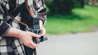 man taking photo on retro camera