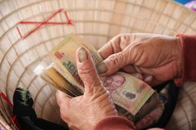 Close-up of the colorful banknotes in the person's hands, in Hoian, Vietnam