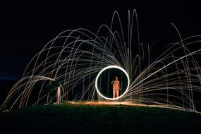 Man with the colorful, bright circle and lights, at night