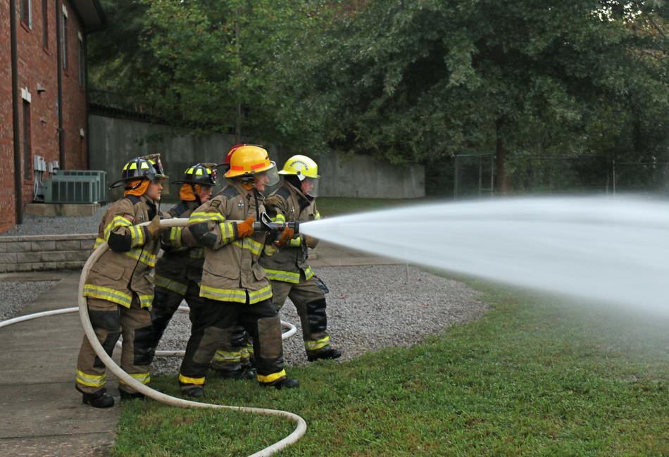 people in helmets extinguishing the fire