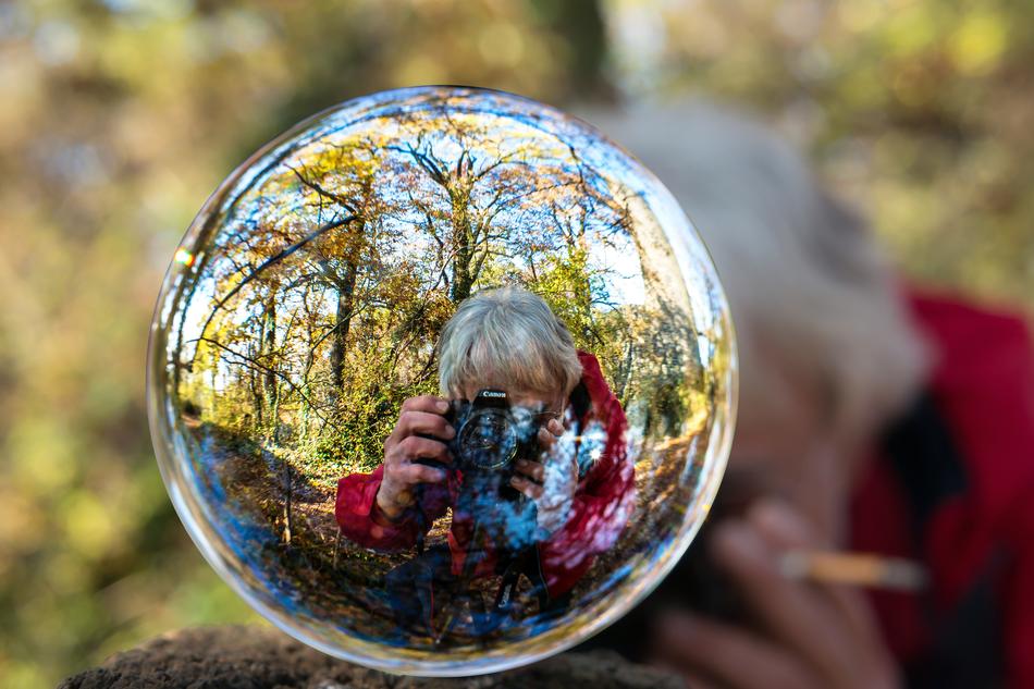 image of a man with a camera through a glass ball