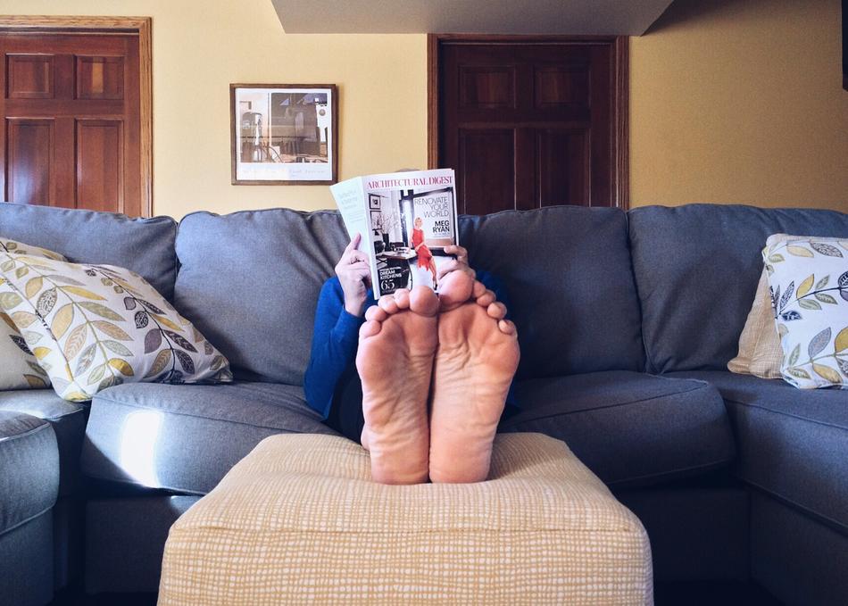 man relaxing on couch with magazine