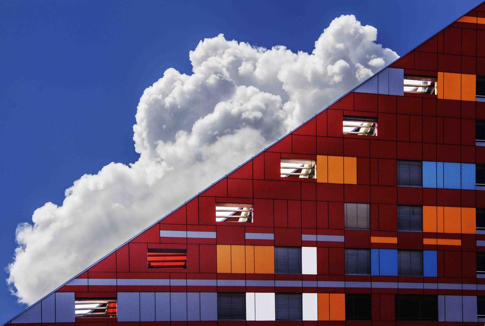 glass modern building on a background of clouds