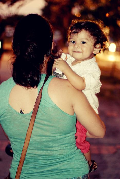 a woman with a baby in her arms standing with her back to her