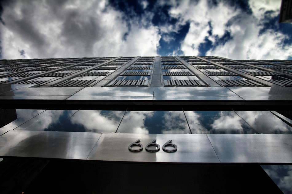 reflection of white clouds in the glass facade of the building