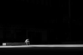 Man sits on bench at darkness