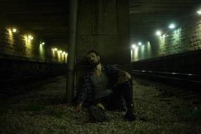 young man resting in a railway tunnel
