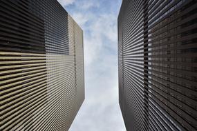 Low angle shot of the shiny buildings, at blue sky with white clouds