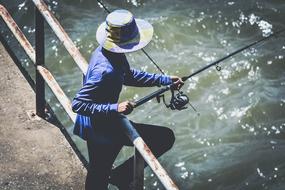 Fisherman, man with Fishing Rod on pier at water