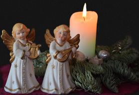 Christmas figures of angels near a candle