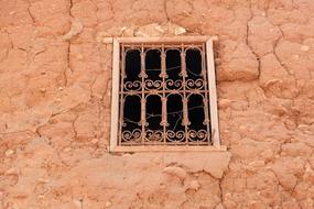 Beautiful, patterned window of a clay house in the desert, in Azgour, Morocco