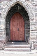 entrance door in a stone arched doorway