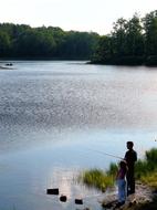 daughter and father are fishing on the lake