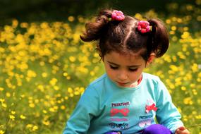 little girl on a meadow among yellow flowers in a blurry background