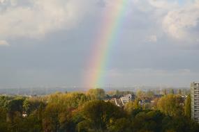 Rainbow over forest and city