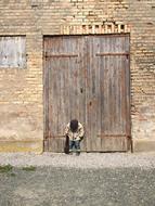 head-down boy at the wooden gate in the port