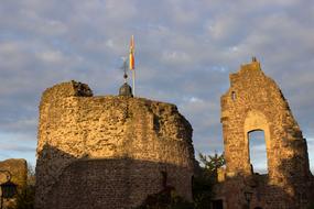 flag on ruins of medieval Hayn castle in the light and shadow at evening, germany, Dreieichenhain