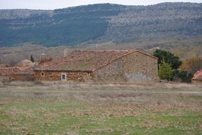 old stone house in the background of mountains in soria, spain