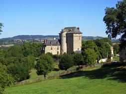 medieval castle on a green hillside in Aveiron, France