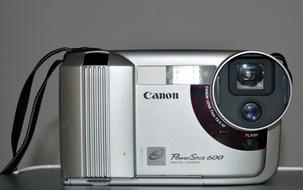 Close-up of the shiny, silver and black "Canon" camera, with the lens