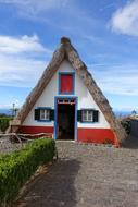 Colorful and beautiful house in Madeira, Portugal, at blue sky with white clouds