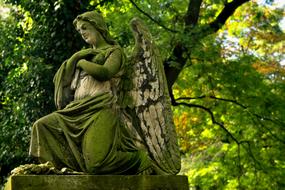 green angel statue on a tombstone