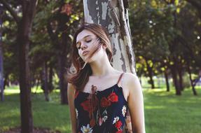 girl in a dress with a picture of flowers in the park
