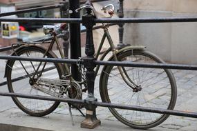 Rusty bicycle, near the railing, among the buildings