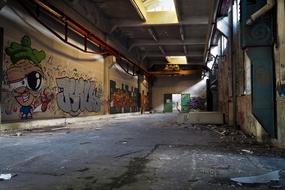 Landscape of the old, abandoned factory with the colorful graffities, in light and shadow