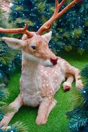 Reindeer lays beneath fir tree, christmas decoration