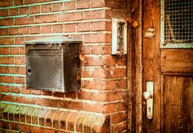 mail box on brick wall of abandoned building