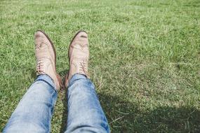 feet in gray shoes on the grass